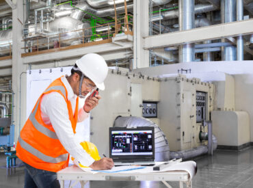 Engineer using laptop computer for maintenance equipment in thermal power plant factory